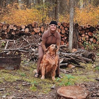 Megan Edgar, one of the Biosphere's newest board members with her dog in the woods