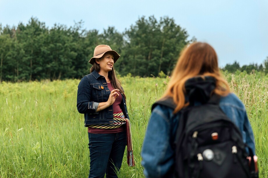 Standing in a meadow, Caitlin Hart listens intently to Natalie Pepin.